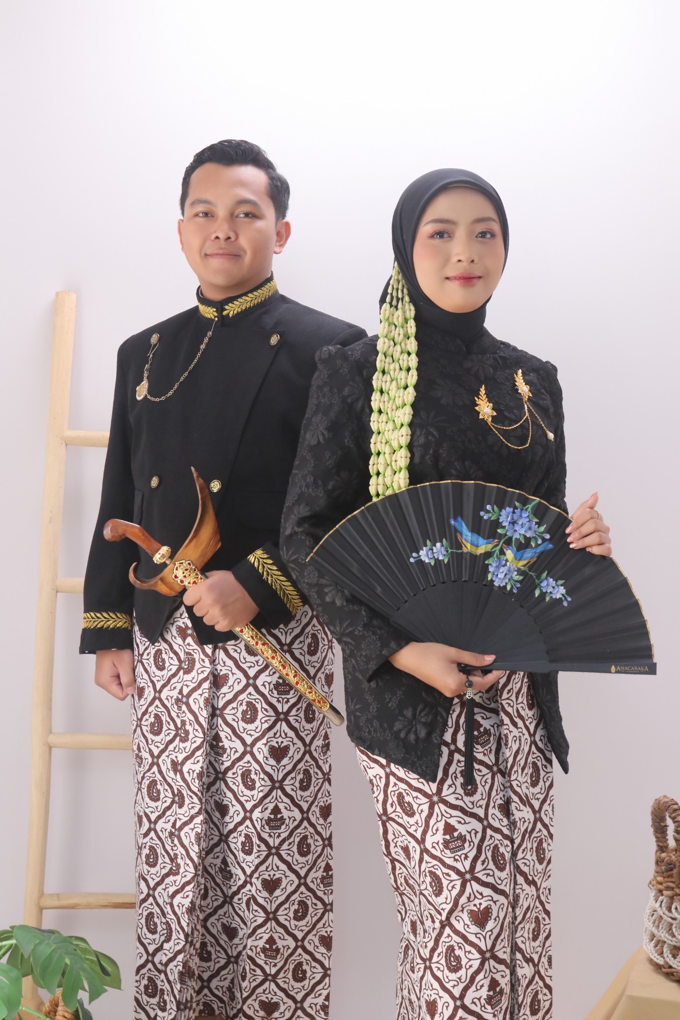 Nila dan Arief berdiri mengenakan busana adat Jawa